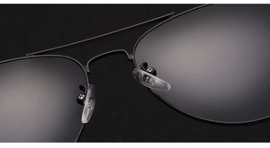 Macro detail of black metal aviator sunglasses showing soft silicone nose pads and bridge