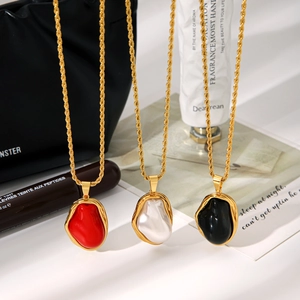Detailed shot of Baroque pearl necklaces with twisted chains in red, white, and black enamel
