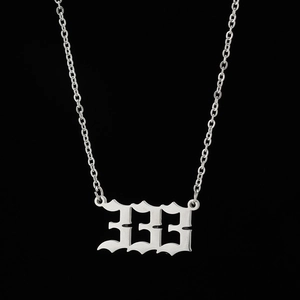 Macro shot of silver angel number 333 pendant with gothic font on O-chain necklace