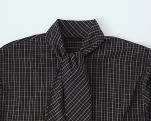 Detailed close-up of dark plaid cotton shirt neckline with stylish lace-up design