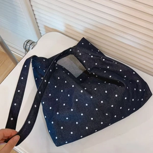 Detail of a retro navy denim tote bag featuring white polka dots and soft texture