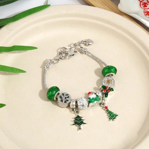 Macro detail of Christmas theme DIY charm bracelet with colorful enamel beads and silver chain