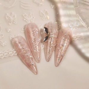 Pink glitter stiletto press-on nails with white butterfly bows and pearl accents