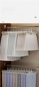 Detail view of adjustable non-slip metal clips on a stainless steel pant hanger for closets