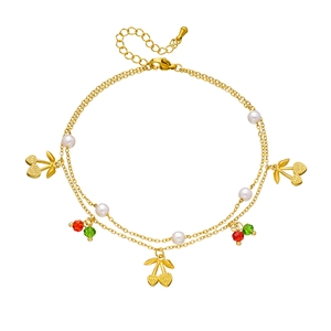 Double-layered golden anklet with cute cherry pendants and white pearls on white background