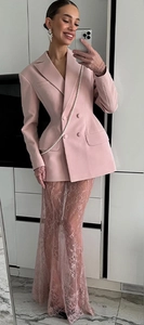 Detail view of pink double-breasted blazer and sheer lace skirt for elegant women's suit