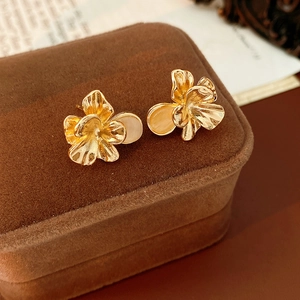 Close-up of golden vintage flower earrings with cat eye stone on velvet jewelry box