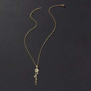 Detail of gold rose pendant with custom cursive script name on a black background