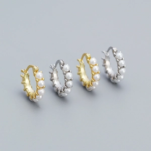 Detail showing gold and silver hoop earrings with inset pearls in a symmetrical layout