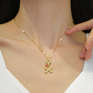 Elegant gold bear necklace with sparkling rhinestones and red stones on a female model