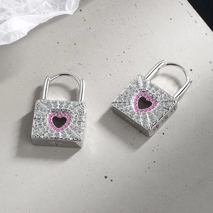 Detailed macro view of S925 sterling silver heart lock earrings with pink and white cubic zirconia