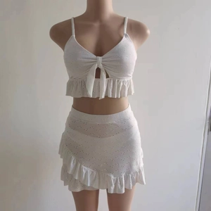 Détail de broderie anglaise blanche sur un maillot de bain trois pièces à volants