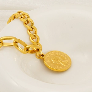Vintage gold chunky chain bracelet with Queen Elizabeth II coin pendant on ceramic