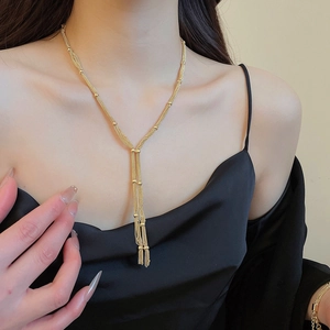 Close-up of golden multi-layered fringe necklace and matching bracelet set on a model