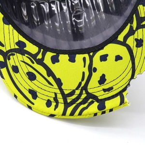 Close-up of embroidered cartoon smile pattern with high-quality stitching on yellow canvas hat