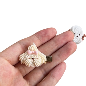 Creative resin cream puppy cookie hair clip with pink bow shown on white background