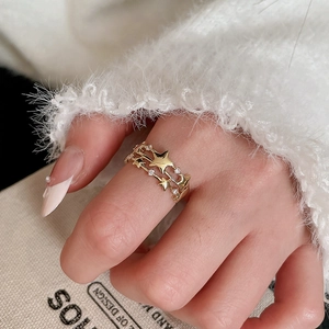 Close-up of golden triple-layered star ring featuring sparkling white zircon accents