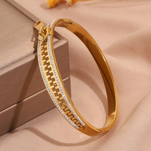 Detailed close-up of a gold zipper shaped stainless steel bracelet with sparkling zircons