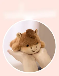 Close-up of a soft plush animal doll held in hands with a cute brown fuzzy texture