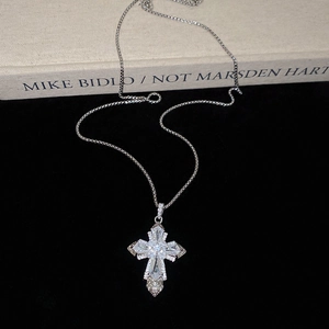 Detailed macro view of silver cross pendant with sparkling zircon inlays on dark background