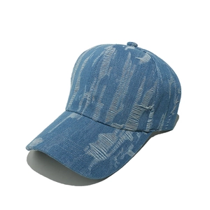 Detail shot of blue denim baseball cap with vintage distressed ripped holes and stitching