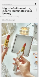 Macro shot of silver handheld makeup mirror reflecting a red lipstick in a lifestyle setting