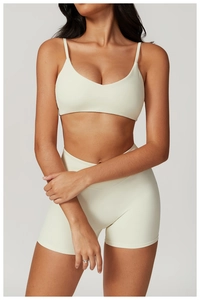 Detail view of cream-white ribbed yoga set with thin straps and high-waist shorts