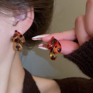 Macro shot of resin tortoiseshell leopard print earrings with a glossy teardrop design