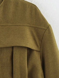 Detailed close-up of collar and shoulder seams on olive green twill fabric jacket