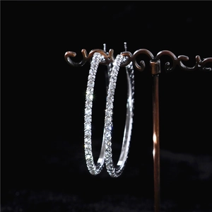 Detailed view of oversized silver hoop earrings with shimmering crystal rhinestones