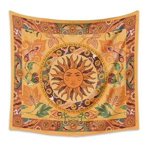 Detail of bohemian mandala tapestry featuring a sun face and zodiac signs on fabric