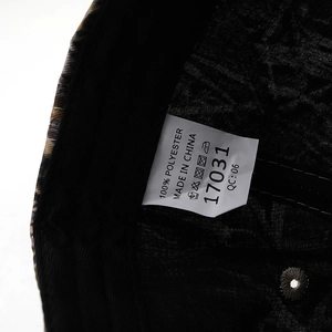 Close-up of baseball cap wash care label showing 100% polyester material info