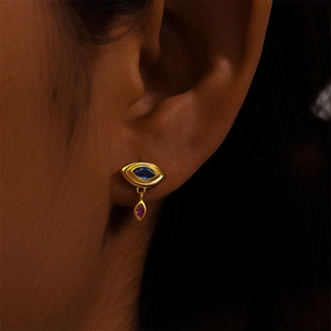 Close-up of S925 silver evil eye earring with blue and pink crystals on model