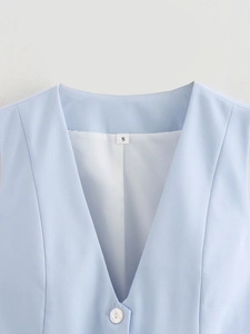 Gros plan sur le gilet bleu clair à col en V montrant le tissu sergé et l'encolure