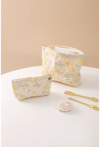 Détails de broderie florale sur trousses en toile beige avec tirette de fleur