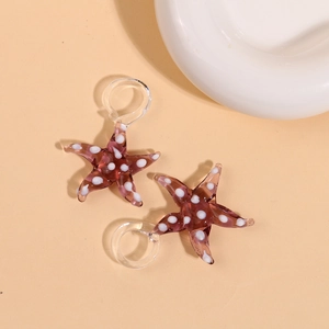 Macro view of purple 3D glass starfish charms with white dots for jewelry making