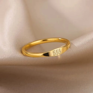 Polished gold titanium steel ring with 555 angel number engraving on a satin background