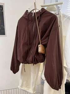 Detail view of brown hooded zipper jacket with adjustable drawstring hem and elastic cuffs
