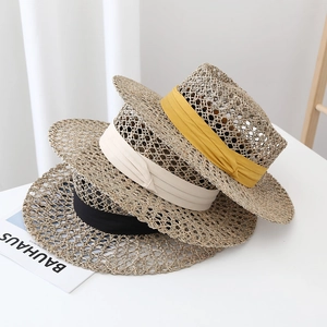 Macro detail of breathable seagrass weave texture on flat top straw hats with satin ribbons
