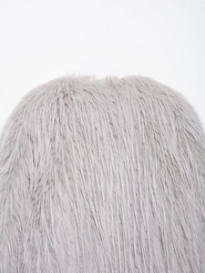Close-up of high-quality light gray faux fur texture and long plush material on a coat