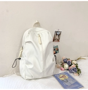 Detailed view of large white casual backpack with smooth texture in a campus lifestyle setting