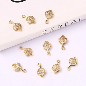 Macro view of nine gold leaf pendants with cubic zirconia inlay on a white magazine