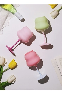 Close-up of three colorful macaron-style crystal wine glasses with elegant spiral stems