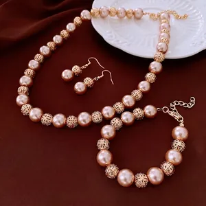 Elegant champagne pearl jewelry set with golden filigree balls on brown velvet