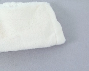 Vue détaillée de la texture de fausse fourrure blanche sur une robe rose extensible
