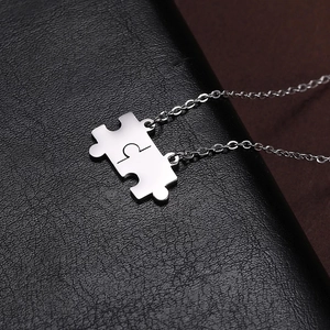 Macro shot of silver puzzle piece pendants on black leather texture background