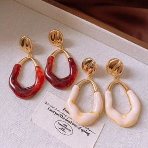 Detail of vintage irregular resin earrings in amber and cream with gold stud accents