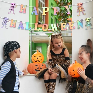 Colorful Halloween Happy Halloween banner with skeleton icons hung above costumed children