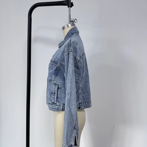 Vue détaillée d'une veste en jean bleu délavé avec boutons métalliques et poches poitrine