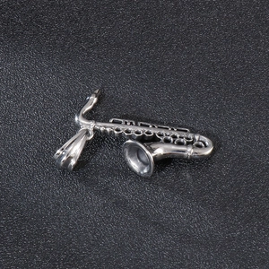 Polished stainless steel saxophone pendant necklace for musicians on a black leather background